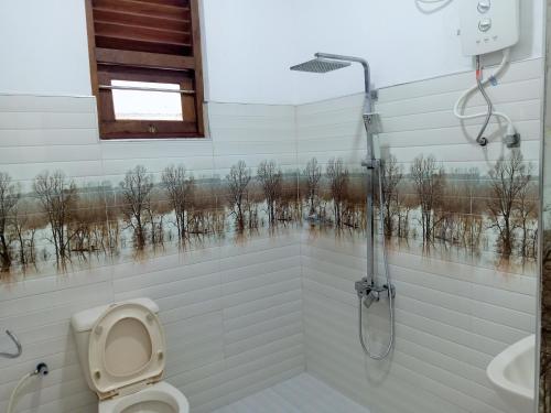 a bathroom with a shower and a toilet and a window at Southern Surf Villa in Dickwella