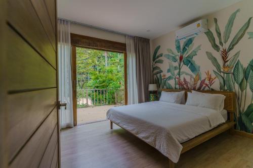 a bedroom with a bed with a tropical painting on the wall at Santi Villa Wat Seree in Ko Phangan