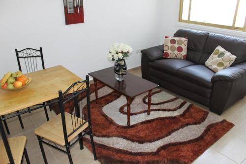 a living room with a couch and a table at Tiffany City Apartments in Larnaka