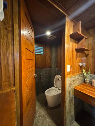 a bathroom with a toilet and a sink at Camp Olli Beach Villas in Dapa