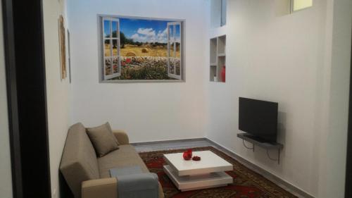 - un salon avec un canapé et une télévision dans l'établissement Casa Origano, à Ispica