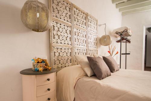 1 dormitorio con 1 cama con mesita de noche y lámpara en Casa Bodega Triana, en Vejer de la Frontera