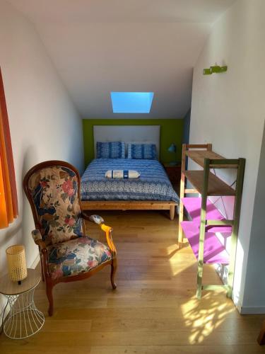 a bedroom with a bed and a chair at Villa des écureuils in Dole