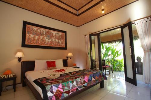 a bedroom with a bed and a large window at Taruna Boutique Homestay & Spa in Pemuteran