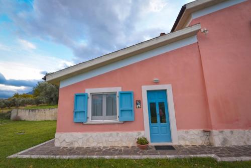 a pink and blue house with a blue door at La Masseria di Villa Giulia in Tocco da Casauria