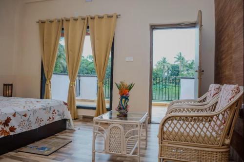 a bedroom with a bed and a chair and a table at Green County Wellness Retreat in Memāri