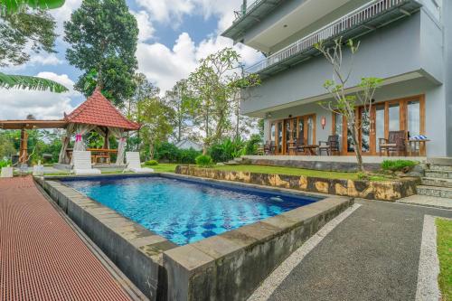 a swimming pool in front of a house at DWM Mandhasativa Homestay By Reccoma in Singaraja