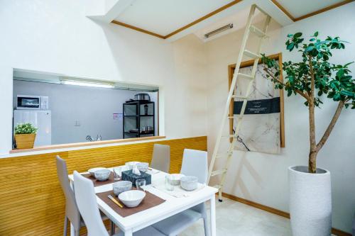a dining room with a white table and a tree at Skytree 12pax Family-Friendly with Indoor Playground in Tokyo