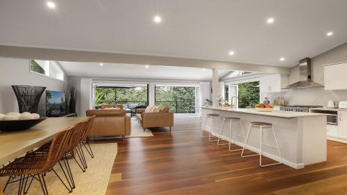 a kitchen and living room with a table and chairs at Arcadia Cottage in Bowral