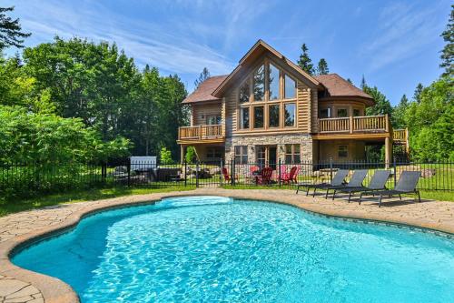 a log home with a pool and a house at Fiddler Lake Resort - Deer 73 in Mille-Isles