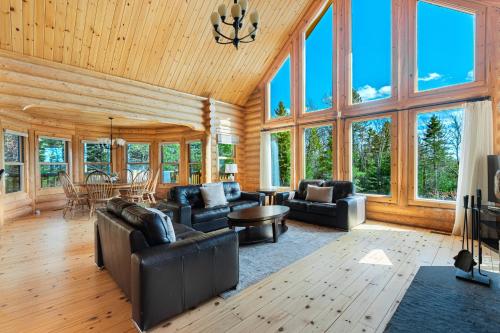 a living room with couches and a table at Fiddler Lake Resort - Deer 73 in Mille-Isles