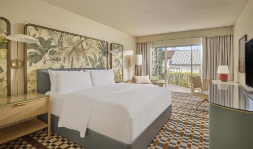 a bedroom with a large white bed and a balcony at Hyatt Centric Delfina Santa Monica in Los Angeles