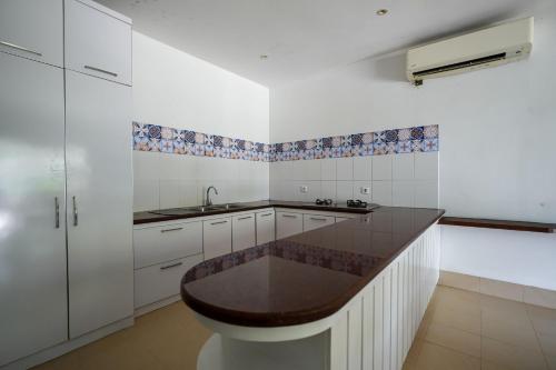 a kitchen with white cabinets and a brown counter top at Kimana Villa in Manggis