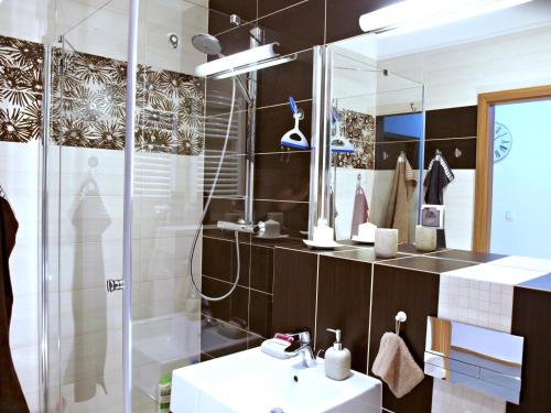 ein Bad mit einer Dusche, einem Waschbecken und einem Spiegel in der Unterkunft Apartament Aga Świnoujście in Świnoujście