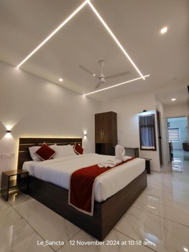 a bedroom with a large bed with a red blanket at Le Sancta homestay in Maraiyūr