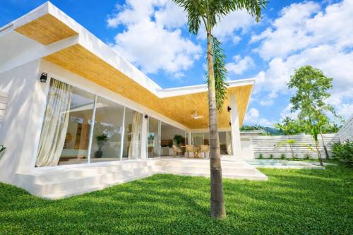 a palm tree in the yard of a house at Modern Private Pool Villa - 3BR - Koh Phangan in Ko Phangan