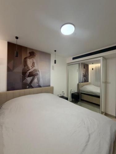 a bedroom with a white bed and a mirror at perfect vacation in Eilat - סוויטת בוטיק מעוצבת לחופשה מושלמת באילת במתחם U360 in Eilat