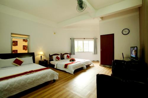 1 dormitorio con 2 camas y reloj en la pared en Tan Da Hotel, en Ho Chi Minh