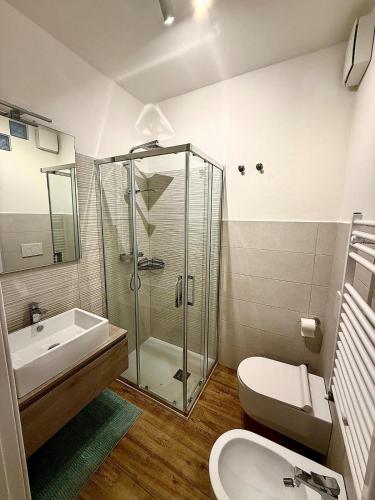 a bathroom with a shower and a toilet and a sink at Maison Piave 35 in Olbia