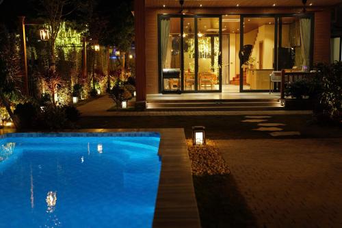 a swimming pool in front of a building at night at Anvi Haven in Sóc Sơn