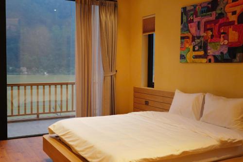 a bedroom with a bed and a large window at Anvi Haven in Sóc Sơn