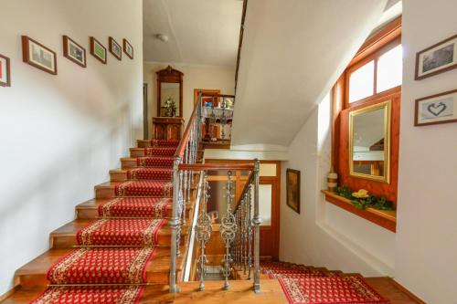 a staircase in a house with a red rug at Frühstückspension Zippo in Greifenburg