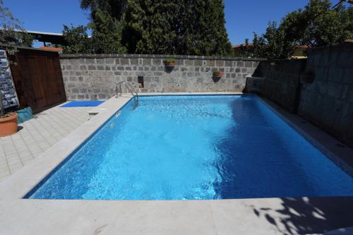 a swimming pool with blue water in a brick wall at Ambrosio Relais in Sorrento