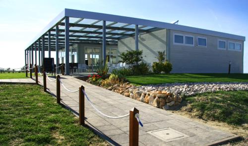 a building with a fence in front of it at Villaggio Camping Adria in Casal Borsetti