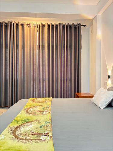 a bedroom with a large bed in front of curtains at Ella Heaven View in Ella