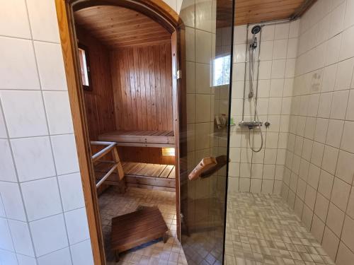 a shower with a glass door in a bathroom at Narvijärven lomamökki in Rauma