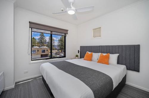 a bedroom with a large bed and a window at Quest Warrnambool in Warrnambool