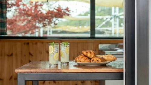 a table with a plate of bread and two drinks at Chaesonghwa Glamping in Yeongcheon in Yeongcheon