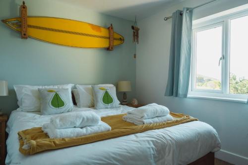 a bedroom with a bed with towels on it at Driftwood in Croyde