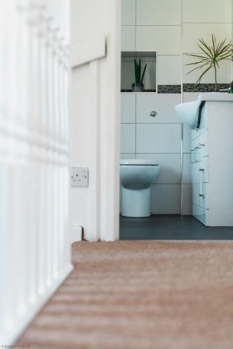 a bathroom with a toilet and a sink at Driftwood in Croyde