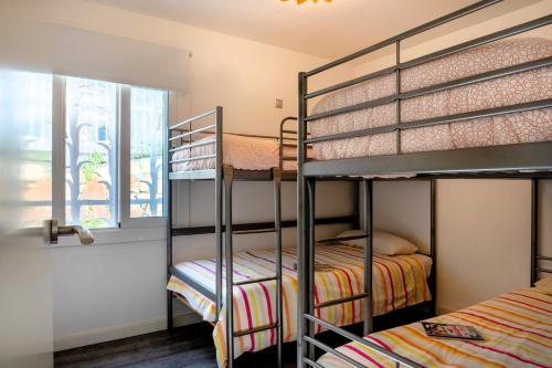 two bunk beds in a room with a window at CBA COSTA BRAVA - Cala Morisca in Tossa de Mar