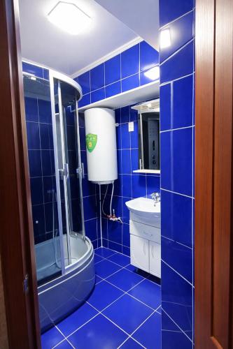 a blue tiled bathroom with a toilet and a sink at Апартамент возле аэропорта in Almaty