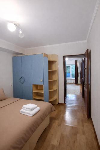a bedroom with a bed with a blue cabinet at Апартамент возле аэропорта in Almaty
