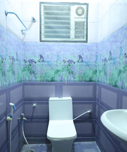 a bathroom with a toilet and a sink at Lakshmi Palace Near Madurai Bus Stand in Madurai