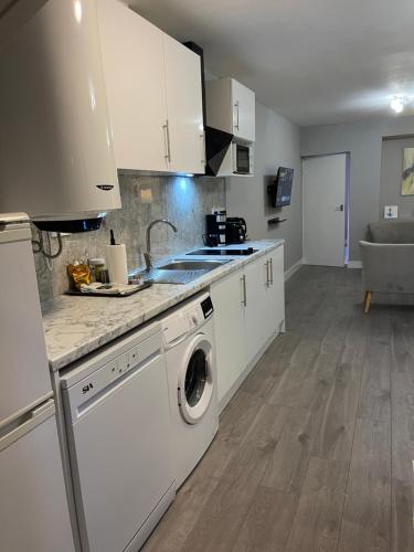 a kitchen with a washer and dryer in it at Chamberlayne Inn in London