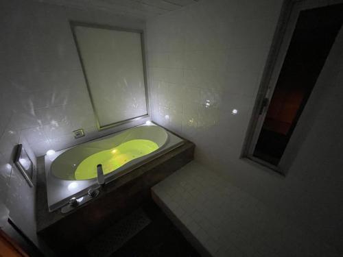 ein Badezimmer mit einem grünen Waschbecken und einem Spiegel in der Unterkunft hotel evi tower 大人専用 in Toda