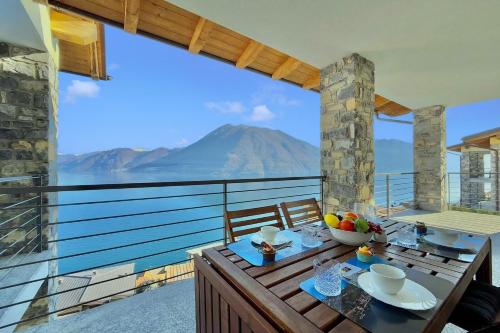 a table on a balcony with a view of a mountain at Residence degli Oleandri 4B in Argegno