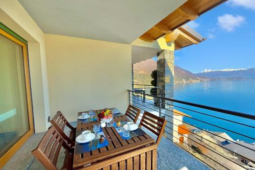 a table on a balcony with a view of the water at Residence degli Oleandri 4B in Argegno