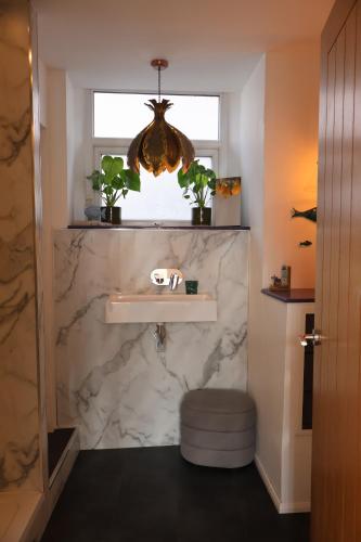 a bathroom with a marble sink and a window at Lighthouse cottage in Watchet