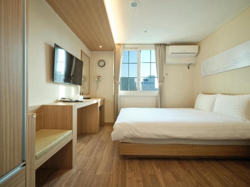 a hotel room with a bed and a television at Uljiro Coop Residence Dongdaemun in Seoul