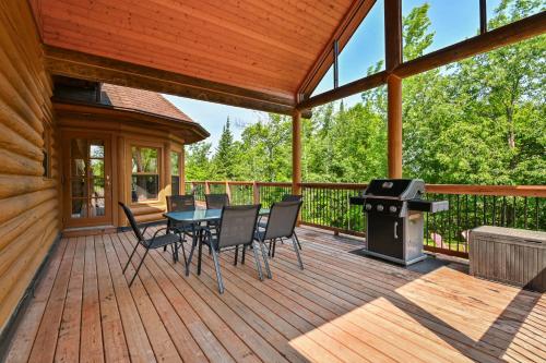 a screened in porch with a table and chairs and a grill at Fiddler Lake Resort - Deer 86 in Mille-Isles