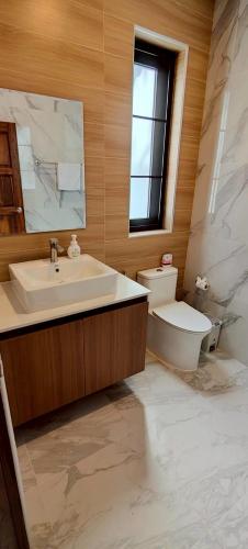 a bathroom with a sink and a toilet and a mirror at Rancho Relaxo Pool Villa in Ban Tai