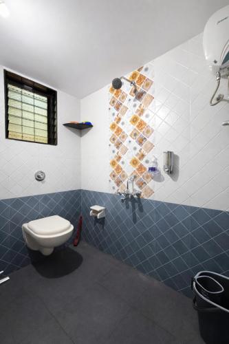 a bathroom with a toilet and a shower at Mangalmurti Farmstay in Pendur