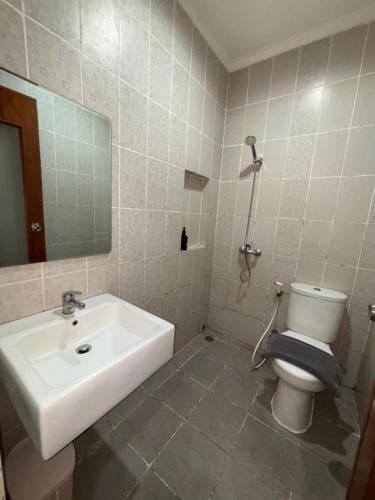 a bathroom with a sink and a toilet and a mirror at MTC Mega Mas Apartment in Manado