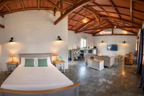 a bedroom with a large bed and a living room at Vanilla Lodge Tropical Garden Suite with Outdoor Stone Bath & Bamboo Shower, inifinity pool in Cap Malheureux