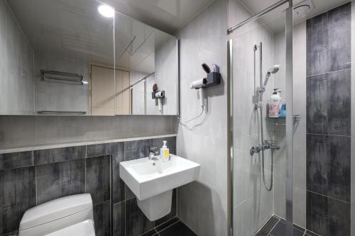 a bathroom with a toilet and a sink and a shower at 김천 포유스테이 in Oksan